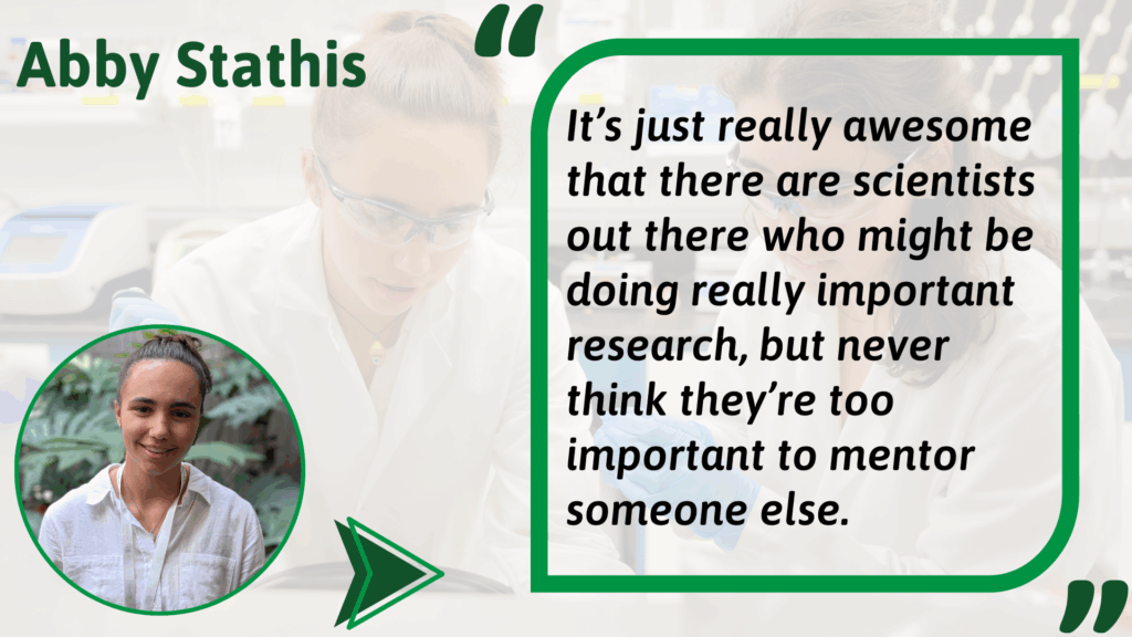 (Abby Stathis) Alt text: Graphic featuring Abby Stathis. On the left is a photo of Abby wearing a white shirt, smiling in front of greenery. On the right is a quote in a green-outlined box over a faded lab background. The quote reads: “It’s just really awesome that there are scientists out there who might be doing really important research, but never think they’re too important to mentor someone else.”