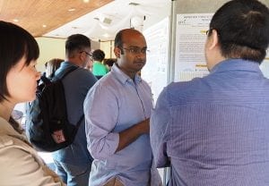 Scientist presenting a poster to two people