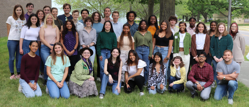 A group photo of 38 undergraduate interns during orientation outside of BTI, with a tree in the background.