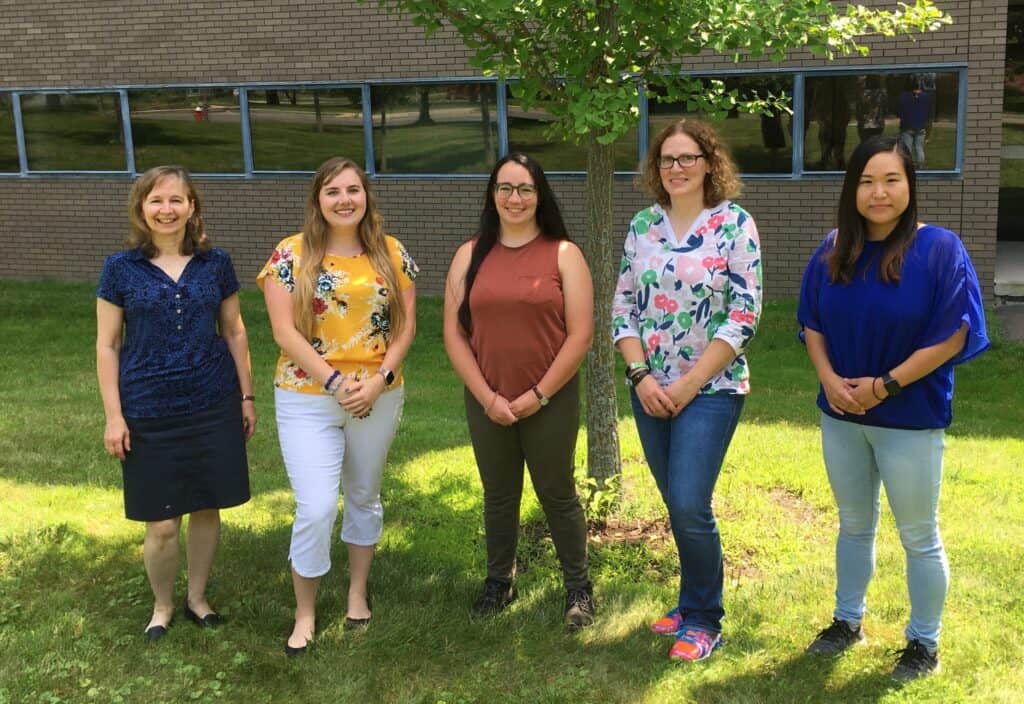 Researchers at Boyce Thompson Institute standing outdoors in front of a brick building with a tree, smiling and posing for a photo.