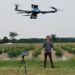 Researcher in a field operating a drone for agricultural or scientific purposes at Boyce Thompson Institute.