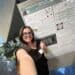 Young woman smiling at research poster on plant pathogen detection at Boyce Thompson Institute conference.