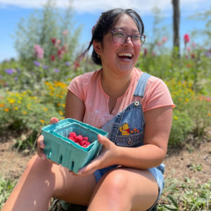 Alexis Chun holding raspberries in a field
