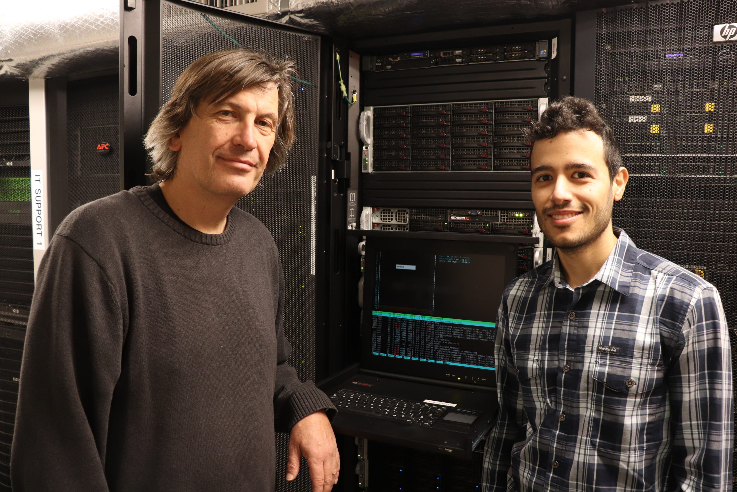 Lukas Mueller and Nicolas Morales pose on either side of a server.