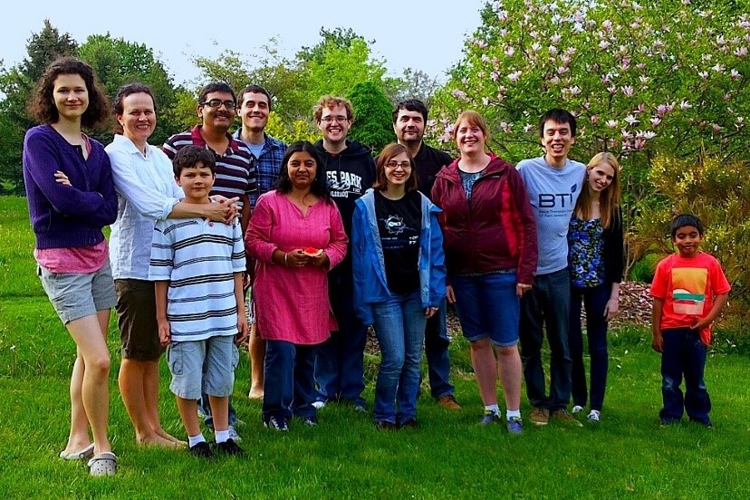 A group photo of Sorina Popescu's lab and family members outside during the summer.